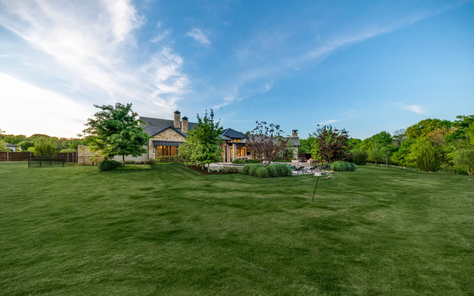 The home is surrounded by a verdant, rolling lawn. (Photo by Costa Christ / Compass)