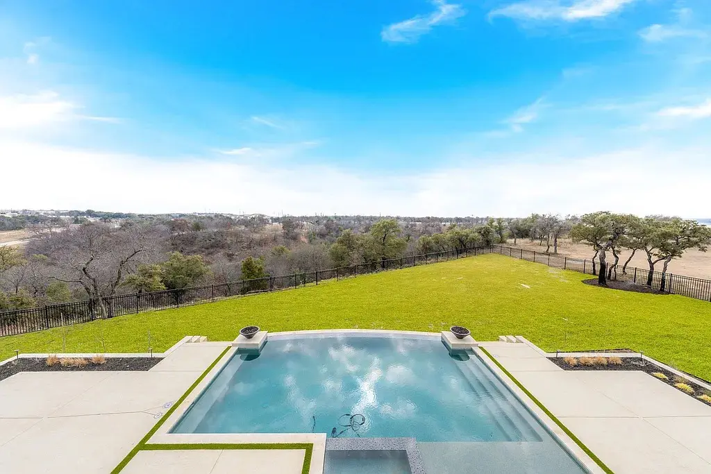 A geometric pool anchors the backyard, where panoramic views and six acres of private property reinforce the estate’s resort-style atmosphere. (Courtesy)