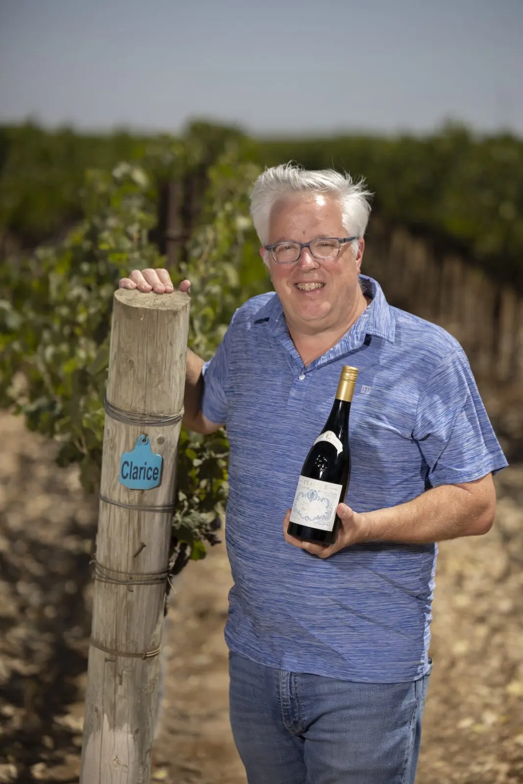 Adam Lee holds a bottle of Clarice pinot noir in Garys' Vineyard.