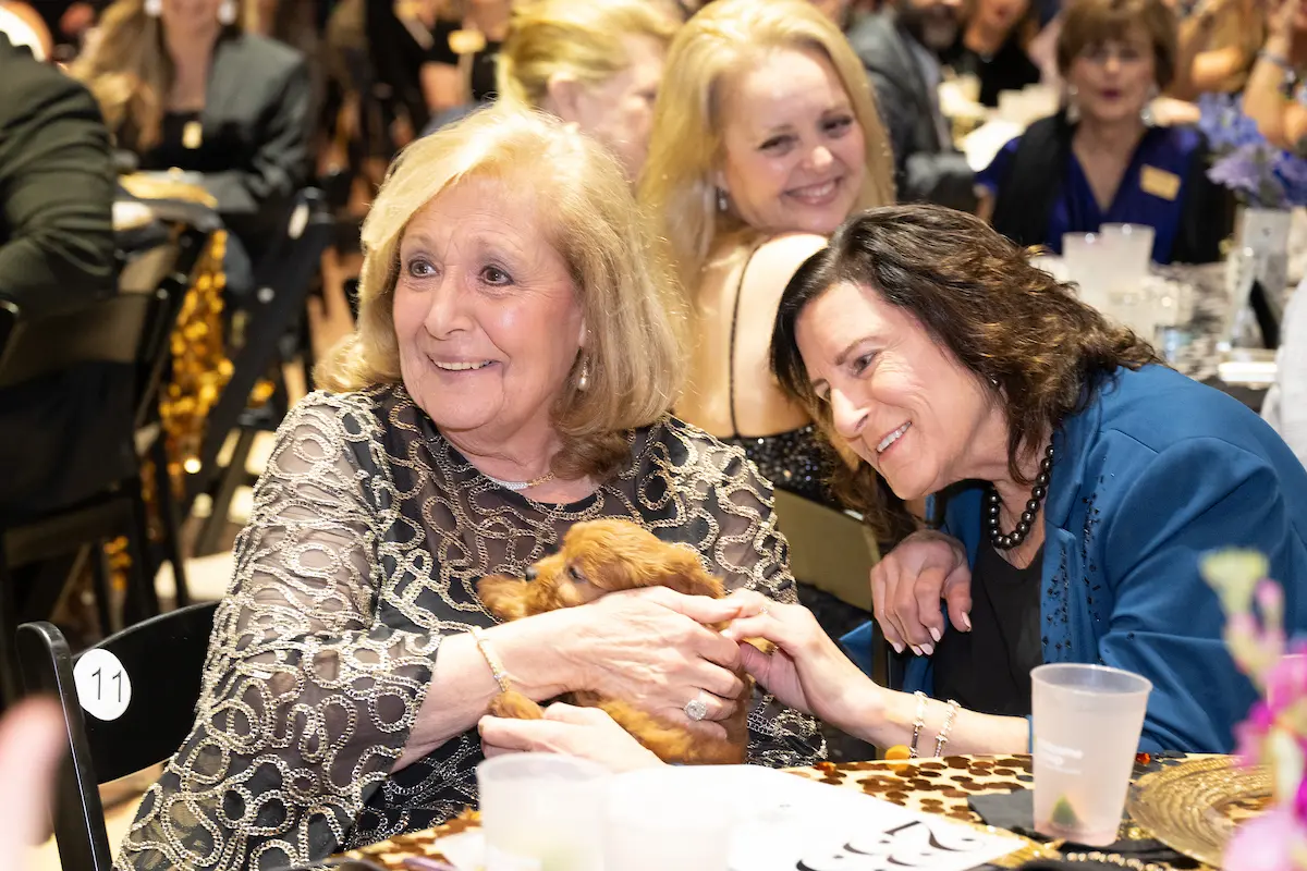Susie Bender with the Cavapoo puppy, Robin Greenspan at the Victory Houston gala (Photo by Wilson Parish)