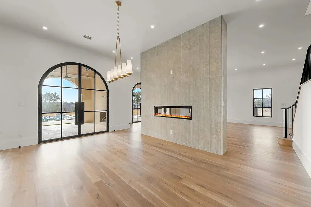 A double-sided linear fireplace subtly divides the home’s open-concept living and dining spaces. (Courtesy)