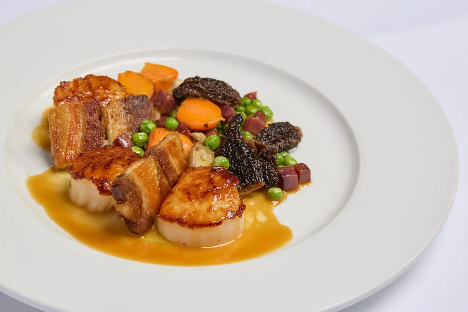 The Sea Scallops & Pork Belly with morels, artichoke, carrots, and peas is a great choice on St. Martin's new menu. (Courtesy)