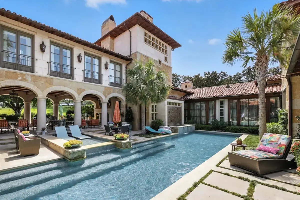 Resort-style amenities at 6236 Indian Creek Drive include a swimming pool framed by arcades, limestone finishes, and views of the surrounding grounds. (Courtesy)
