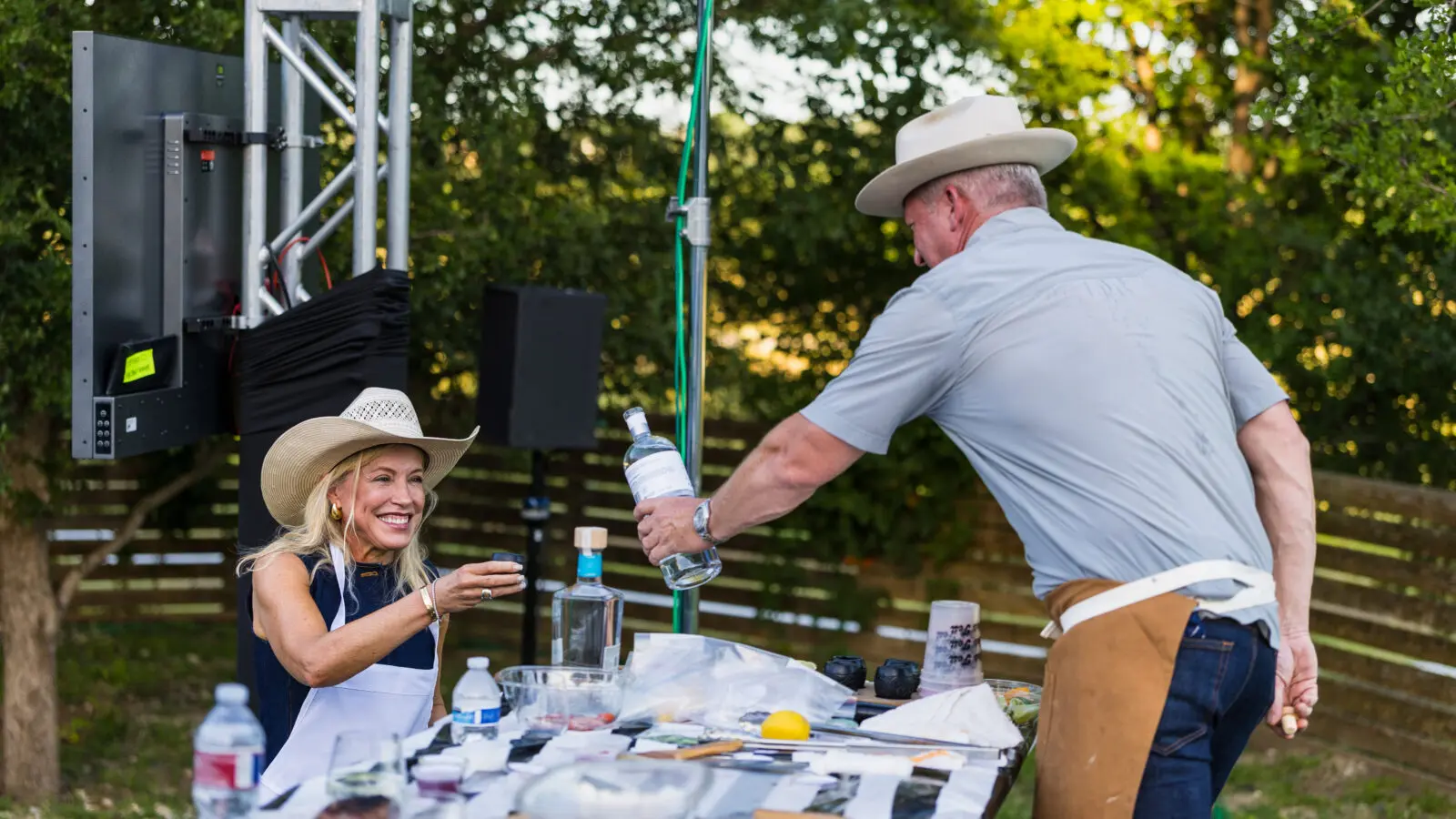 Chef Tim Love pours wine for a guest during Saturday's interactive live-fire cooking experience. (Photo by Land Rover Fort Worth)