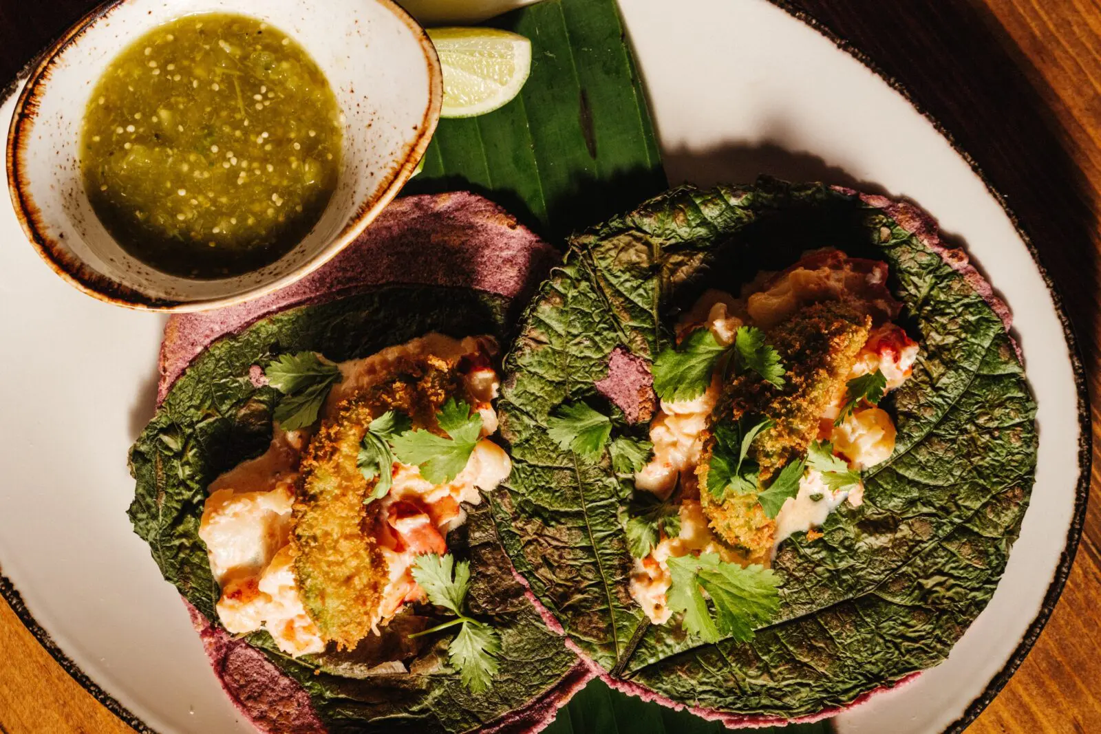 The tacos come with house-made tortillas in varieties like chickpea and black bean, and in the case of their lobster tacos ($28), are pressed with a fresh hoja santa leaf, its anise scent wafting off the warm flat bread. (Photo by Chris Quit Nguyen)