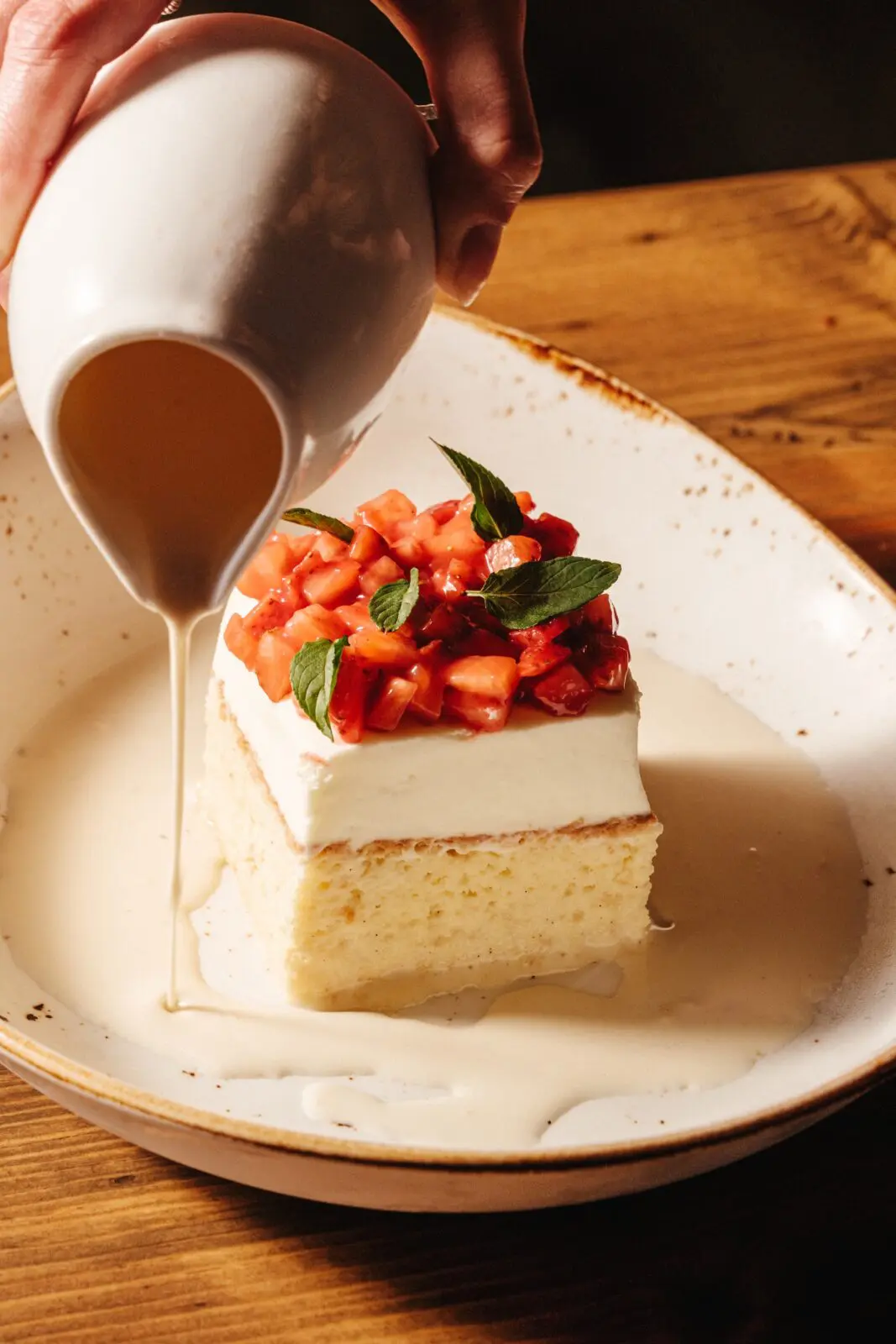 End your meal with their tres leches, topped with fresh sweet strawberries. (Photo by Chris Quit Nguyen)