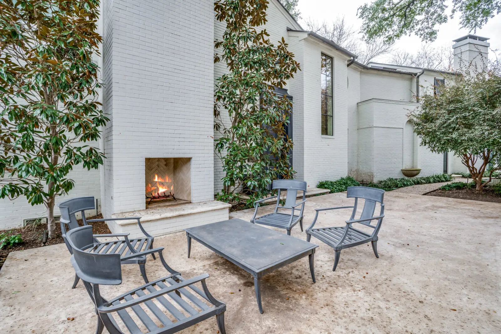 There is a patio with a fireplace near the front door. (Photo by Allie Beth Allman & Associates)