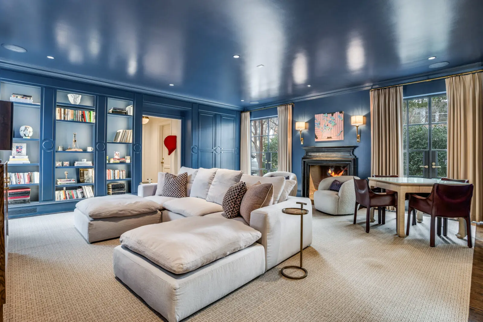 The lacquered lapis blue family room provides the perfect spot for family movie nights, a competitive game of mahjong, or leisurely afternoons reading. (Photo by Allie Beth Allman & Associates)
