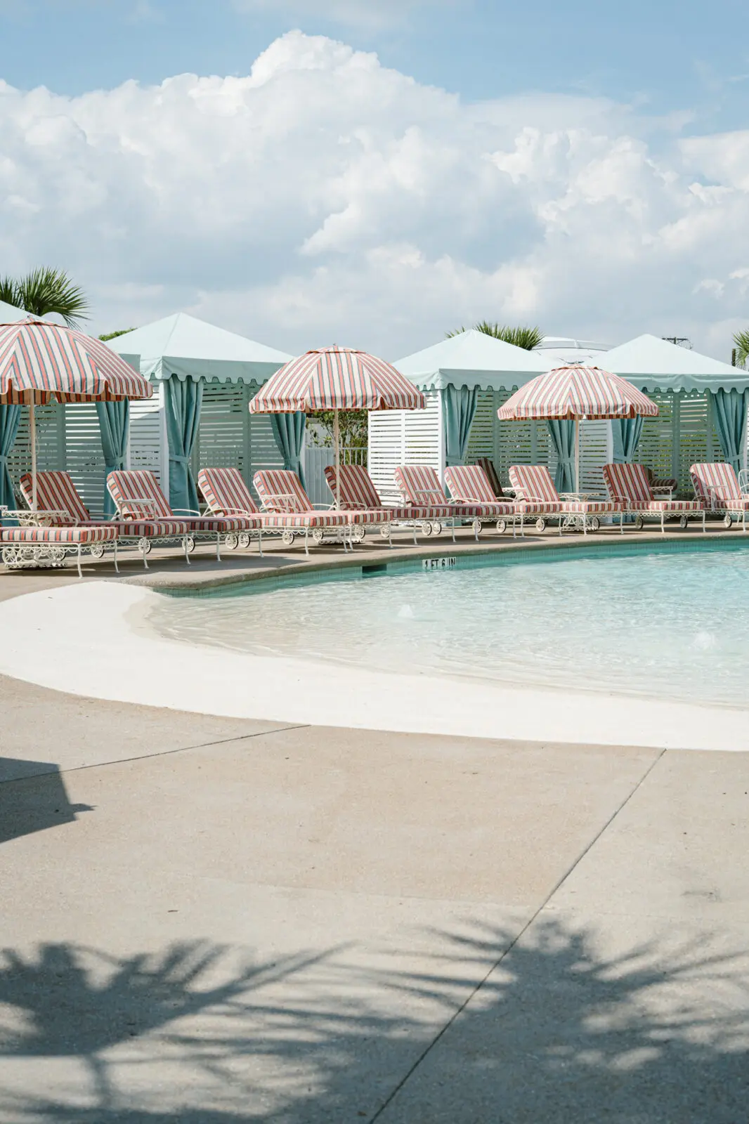 Striped loungers, private cabanas, and a beach-entry pool create a resort-style escape at Caravan Court Hotel. (Courtesy)
