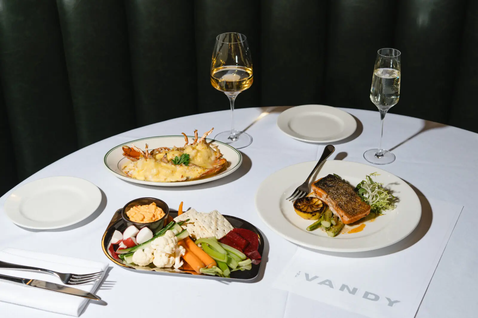 The Vandy serves dishes including lobster thermidor, pan-seared salmon, and a seasonal crudité platter inside Caravan Court Hotel. (Courtesy)