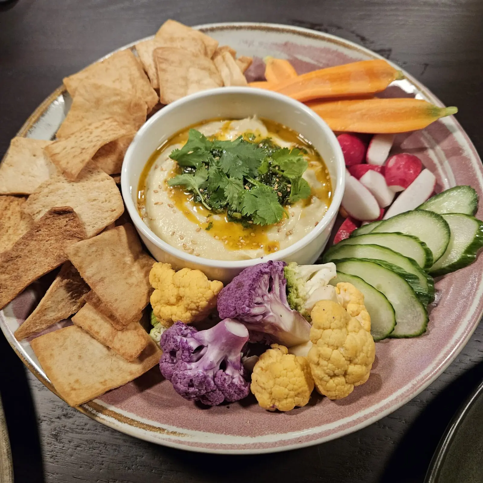 The white bean hummus is served with roasted garlic, cilantro chimichurri, fresh vegetables, and grilled flatbread. (Courtesy)