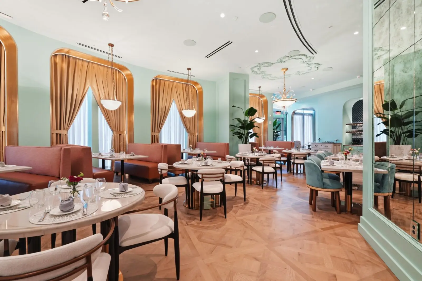 The 5,400-square-foot space recalls the glamour of Hollywood Regency design, with a Rococo-like curved dining room, walls painted Tiffany Blue, and the crowd reflected in foxed mirrors as they sit cossetted in plush floral banquettes. Designed by Laura Loreman Interior Design Studio in collaboration with Culinary Khancepts founders Denise and Omar Khan, the space is finished with sparkling crystal chandeliers, custom reproduction antique furnishings, and golden accents throughout. (Photo by Ben Brown)