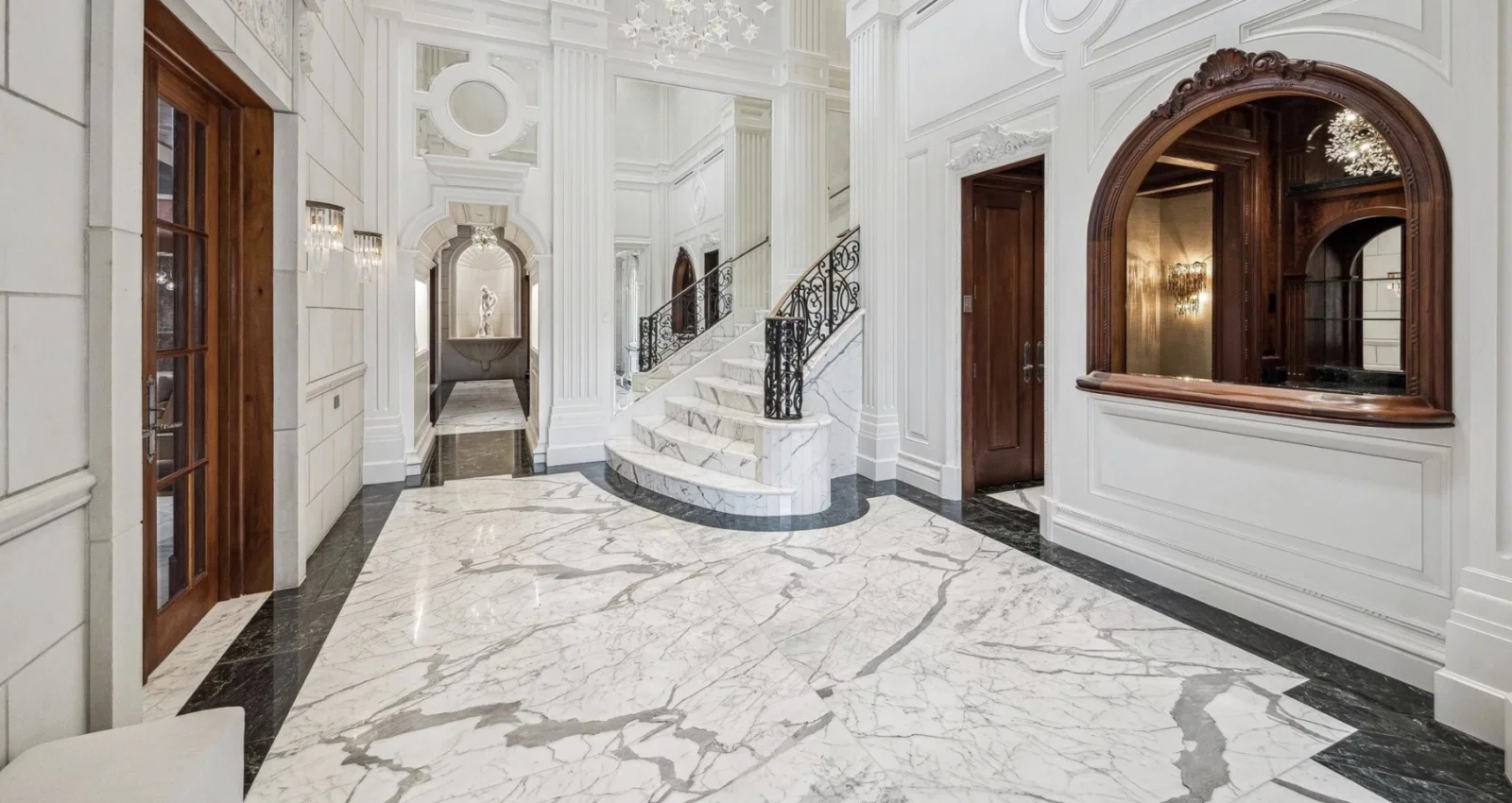 Marble flooring and a crystal chandelier enhance the glamour of the foyer at 1708 River Oaks Boulevard.