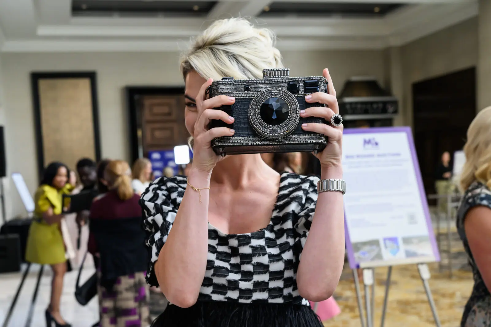 Stela Akman sets the stage at the PaperCity Philanthropy in Fashion Houston Best Dressed Luncheon for a fashion frolic with her crystal encrusted camera handbag (Photo by Michelle Watson, CatchlightGroup.com)