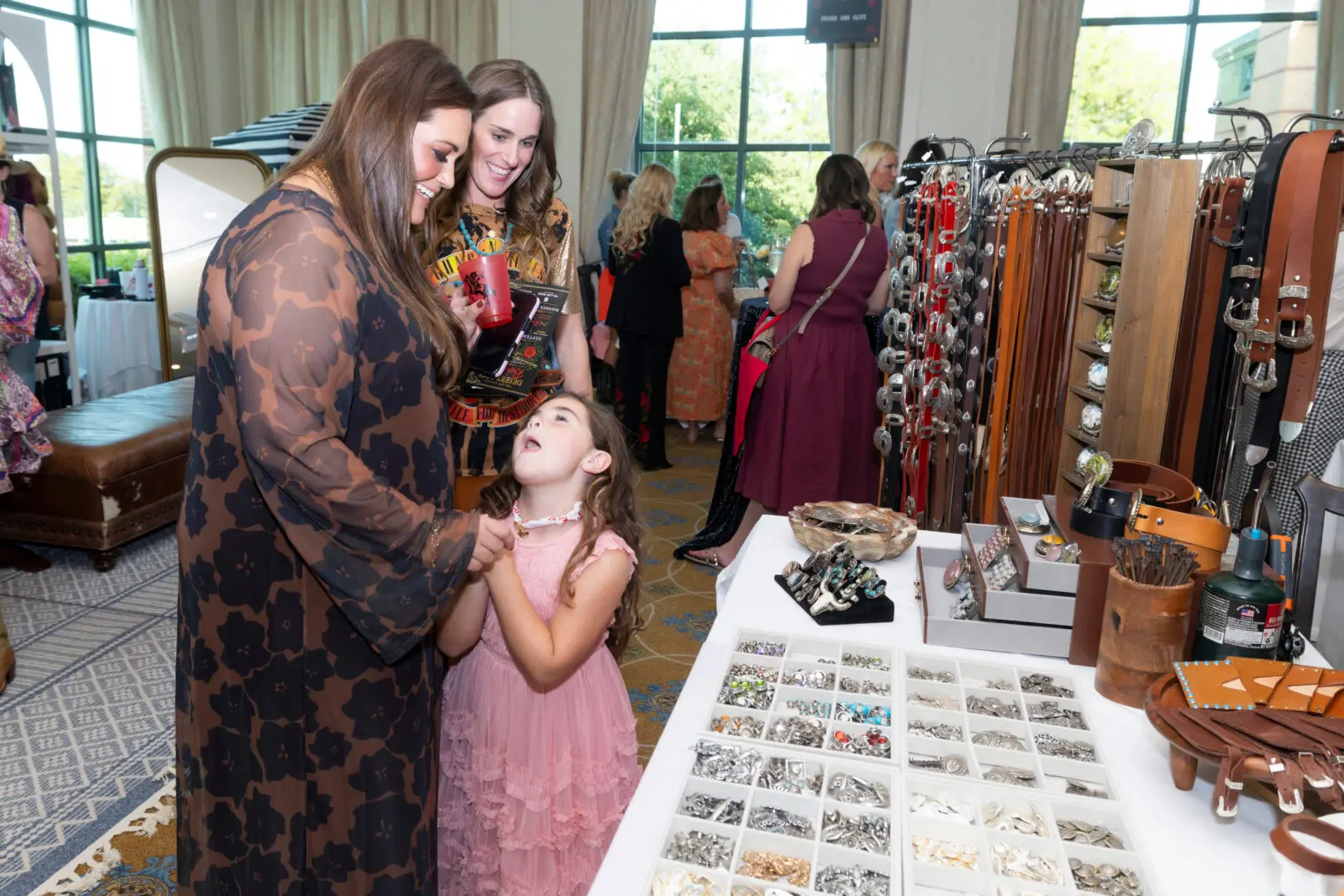 Nina Turney pleads with her mom Allie Turney and Katherine Brown for a custom belt from Lucky Gem Club. (Photo by Sharon Ellman, Ellman Photography)