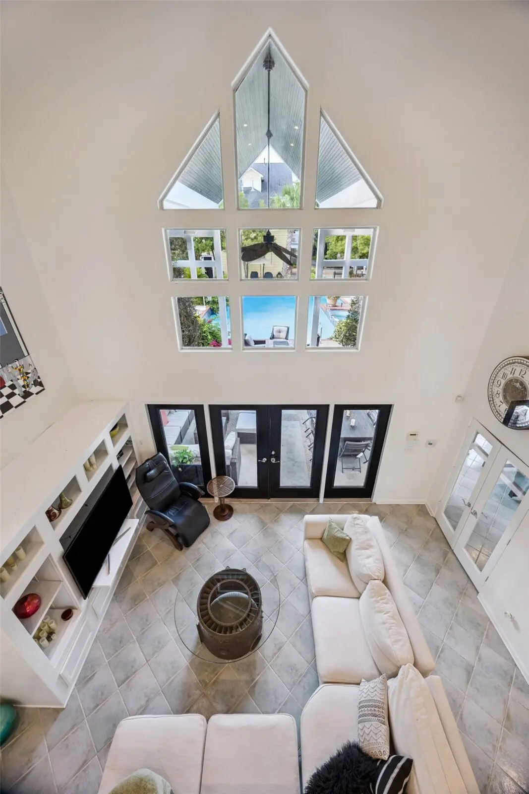 The two-story living room of the pool house enjoys ample light from the elevated window. (Photo by TK Images for Martha Turner Sotheby's International Realty)