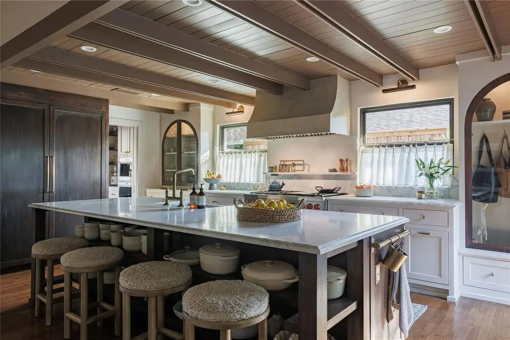 The kitchen features an oversized island with custom cabinetry and all the bells and whistles of appliances, but it’s the tongue-and-groove ceiling that really stands out.
