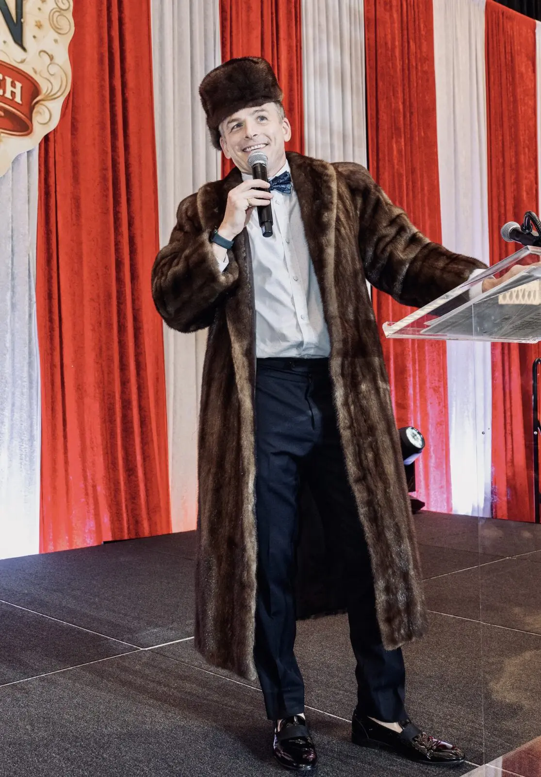 Auctioneer Johnny Bravo modeling a mink coat from the auction at the Mission of Yahweh gala (Photo by Jacob Power)