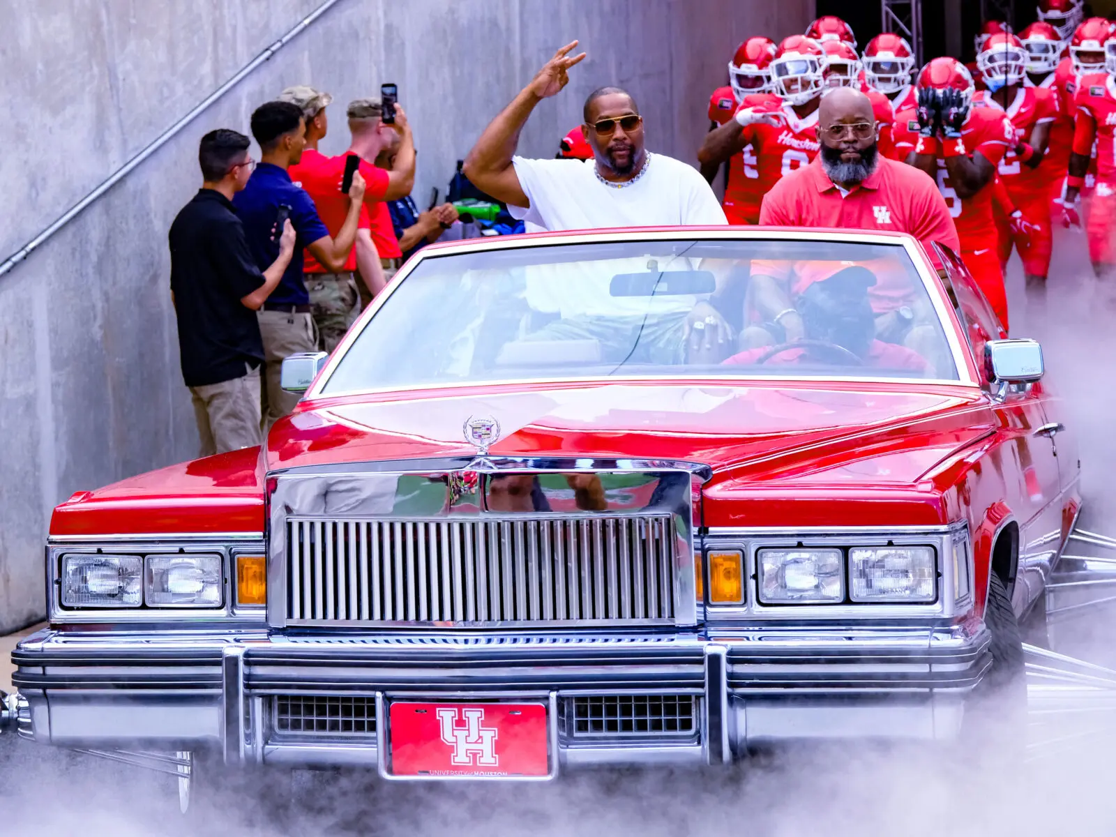 University of Houston's slab stadium walk-in entrance included passengers for the first time. Antowain Smith and Wilbert Brown, part of UH's 1996 conference title team, rode high in the backseat. (Photo by F. Carter Smith)