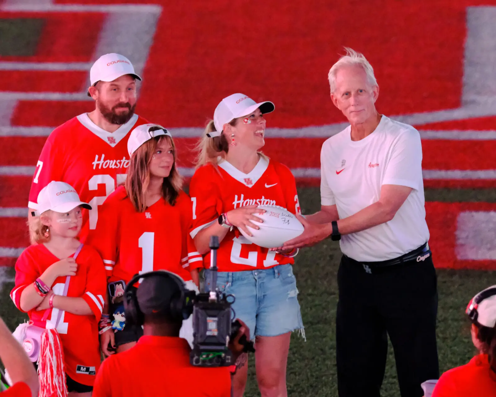 University of Houston special assistant Donn Landholm gives a football to the stem cell donor, Morgan Chalup, who saved his life. (Photo by F. Carter Smith)