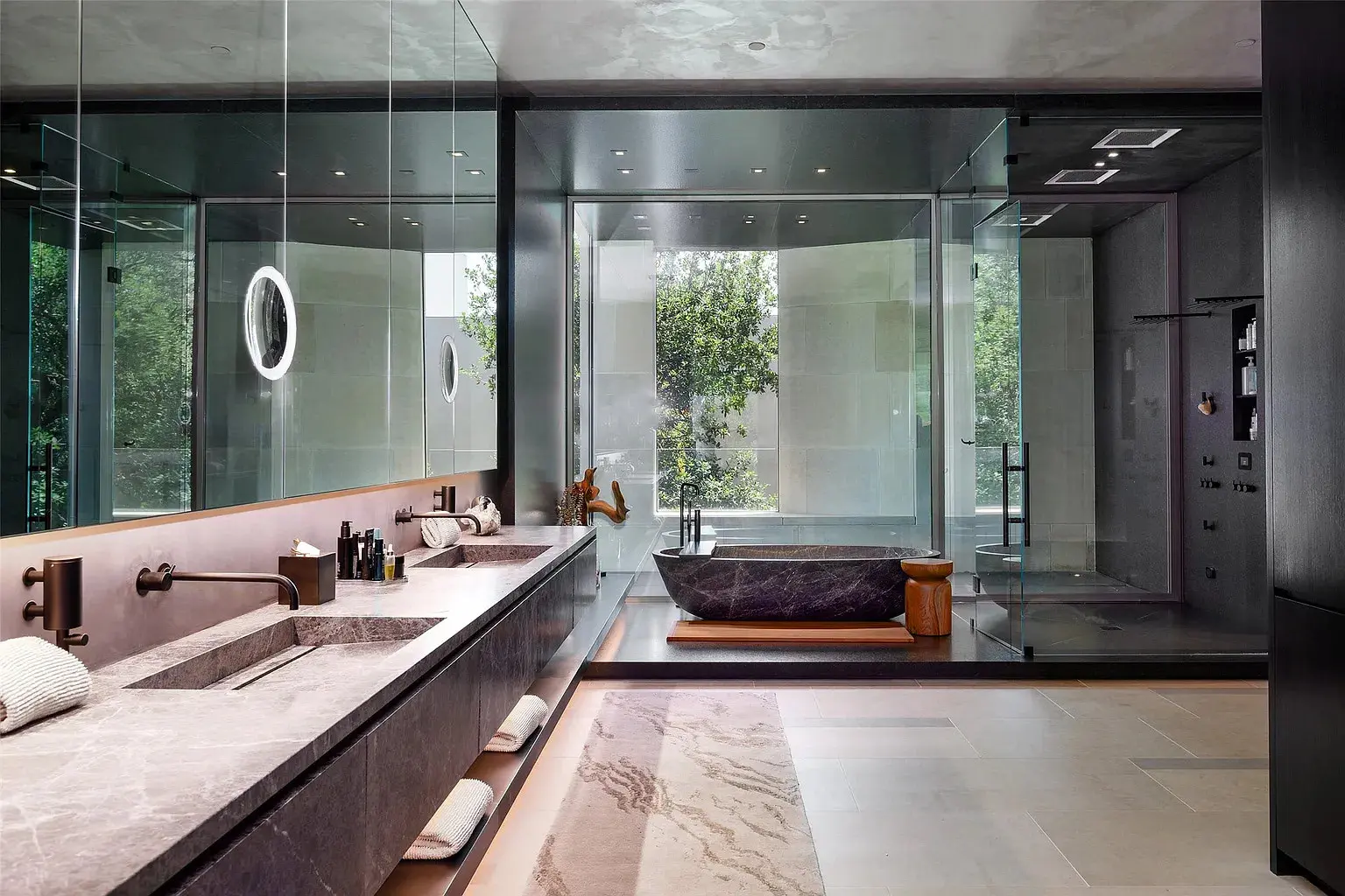 The primary suite features a freestanding soaking tub from a solid piece of stone, a fluted fireplace, and an oversized Poliform closet. (Photo by Stephen Reed Photography)