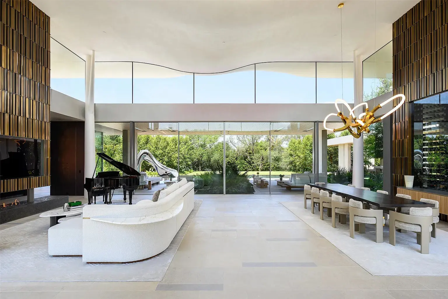 Past the lily pond, magnificent pivot doors open to a light-flooded glassy hallway and dramatic double-volume living space that immediately lets guests know, "Prepared to be dazzled." (Photo by Stephen Reed Photography)