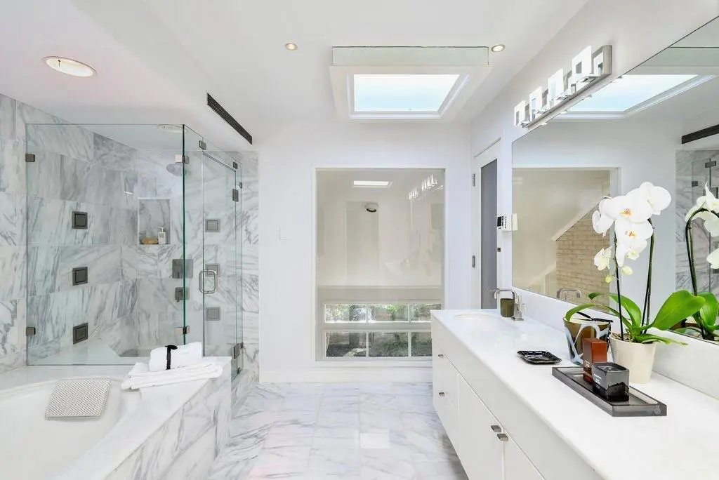 At 4650 Christopher Place, the primary suite bath also features a cedar-paneled hot rock sauna room, cast-iron garden tub that overlooks the garden, separate enclosed shower, and 90-inch floating double vanity.