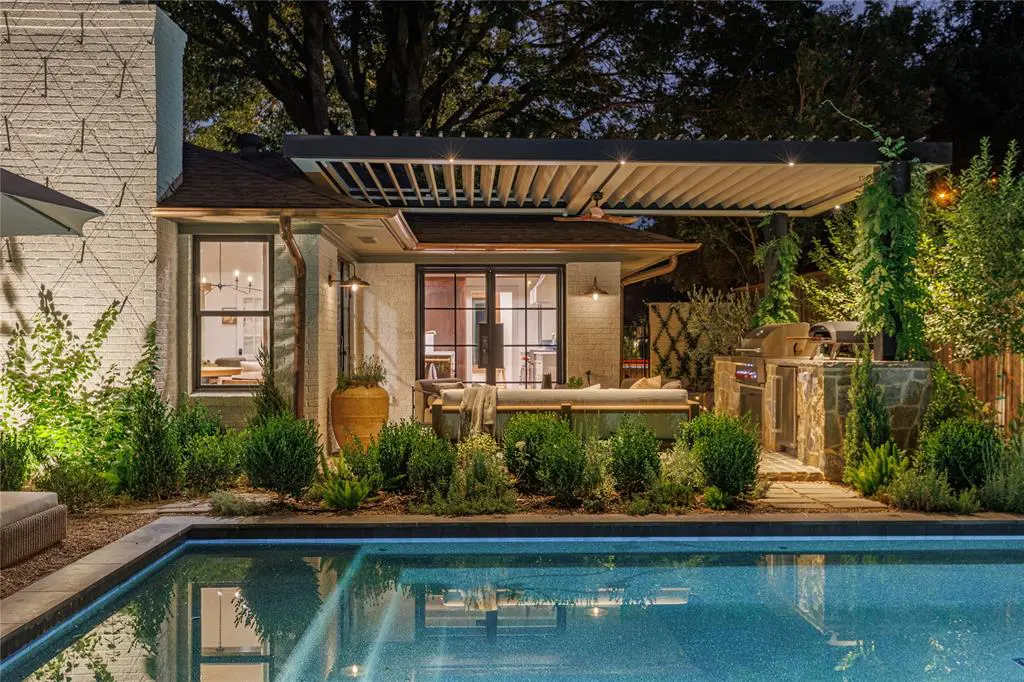 Outside, there’s a pool tucked inside a garden filled with a custom louvered pergola, a full outdoor kitchen, and a detached garden house. 