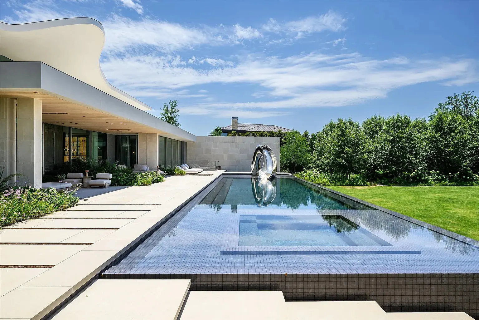  The custom metallic slide looks like a sculpture flanking the end of the pool. (Photo by Stephen Reed Photography)