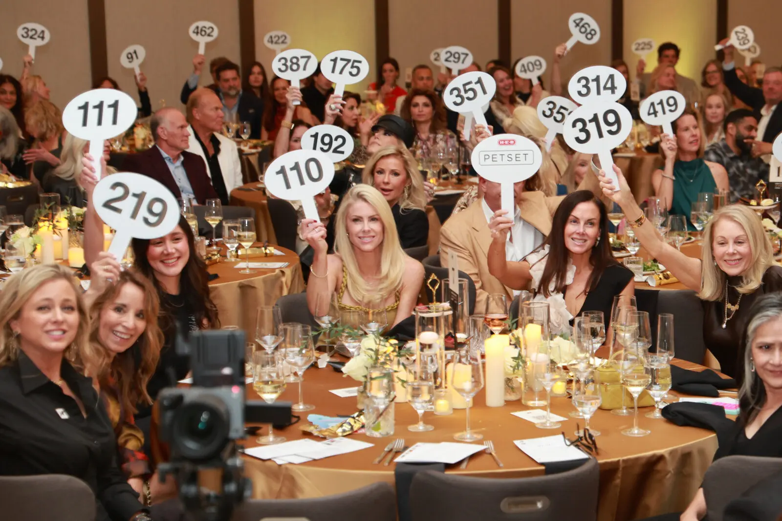 Everybody lifts their bid numbers in support of PetSet at the nonprofit's 'Le Brunch' (Photo by Priscilla Dickson)