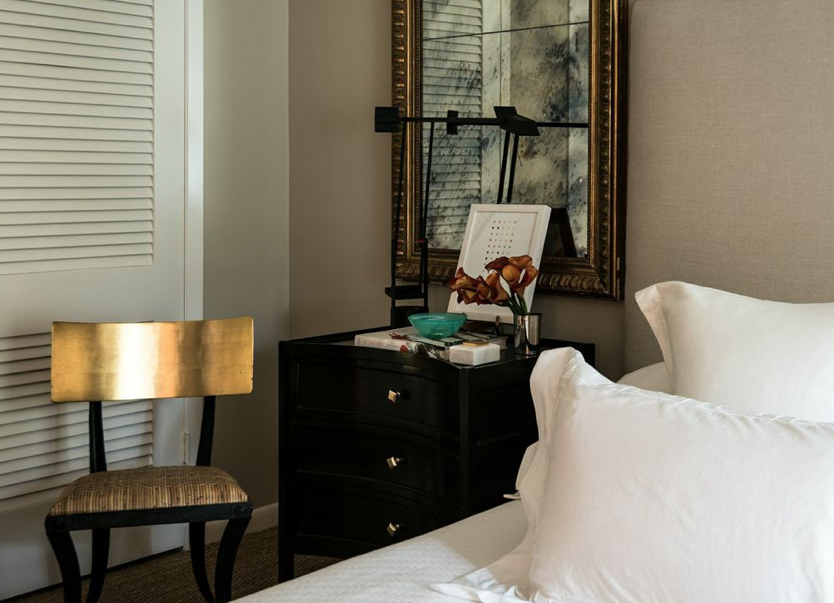 Bedroom detail: side table- Longoria Collection, Tizio lamp, antique mirror, artwork- Minted through West Elm and chair from Wicker Works through David Sutherland.