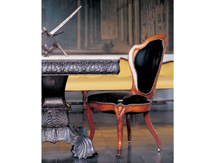A detail in the foyer of an American cast-iron garden table, circa 1860, and an American Victorian laminated rosewood chair, circa 1850 