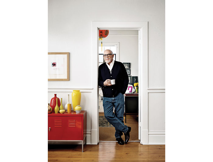 Poised at the entrance to his office, the painter has made the 3,000-square-foot space his own. To left, IKEA cabinet and vintage pottery both provide pops of color.