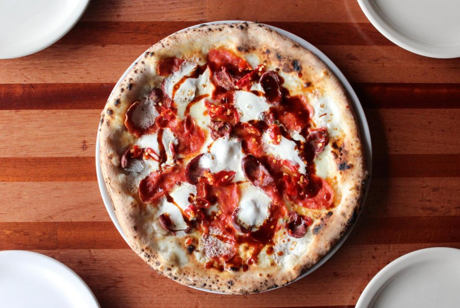 Cane Rosso Pizza with housemade mozzarella and burrata cheeses, sliced Pecan Lodge jalapeno sausage, hot soppressata, Calabrian chiles, and spicy BBQ sauce.
