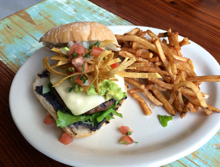 The La Grange Burger: blend of angus beef & brisket patty with refried beans, pepper jack cheese, guacamole, tortilla strips and pico de gallo. 