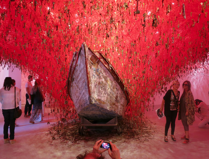 Japanese Pavilion, Giardini: Chiharu Shiota's “The Key in the Hand.”
The artist creates this large-scale installation using several thousand strings of red yarn tied to keys, symbolizing the safeguard of our memories being stored behind the protection of the key to our true feelings. The two boats beneath the keys are meant to capture the rain of memories. One of my favorites.
