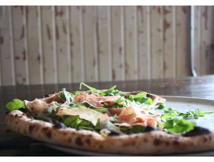 Prosciutto e rucola pizza at Dolce Vita. Tomato, mozzarella, prosciutto and arugula. 