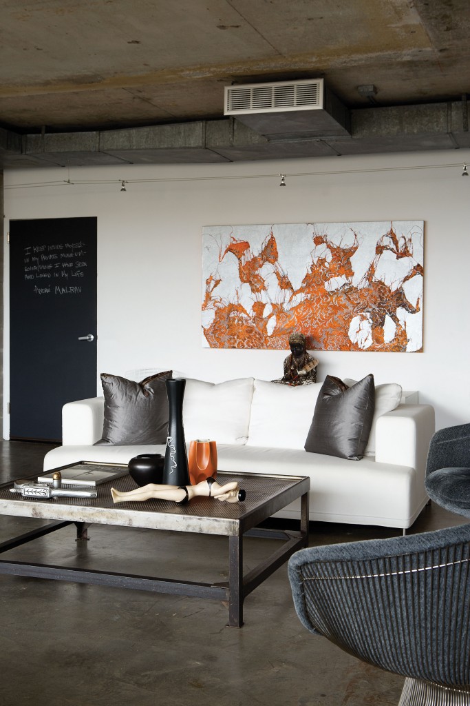 In the living area, the chalkboard bears philosophical phrases. Ligne Roset sofa. Mark Flood lace painting. Coffee table is a vintage French postal sorting table from Kuhl-Linscomb. On the table, vintage Jayne Mansfield water bottle found in New Orleans. Vintage Platner chairs.