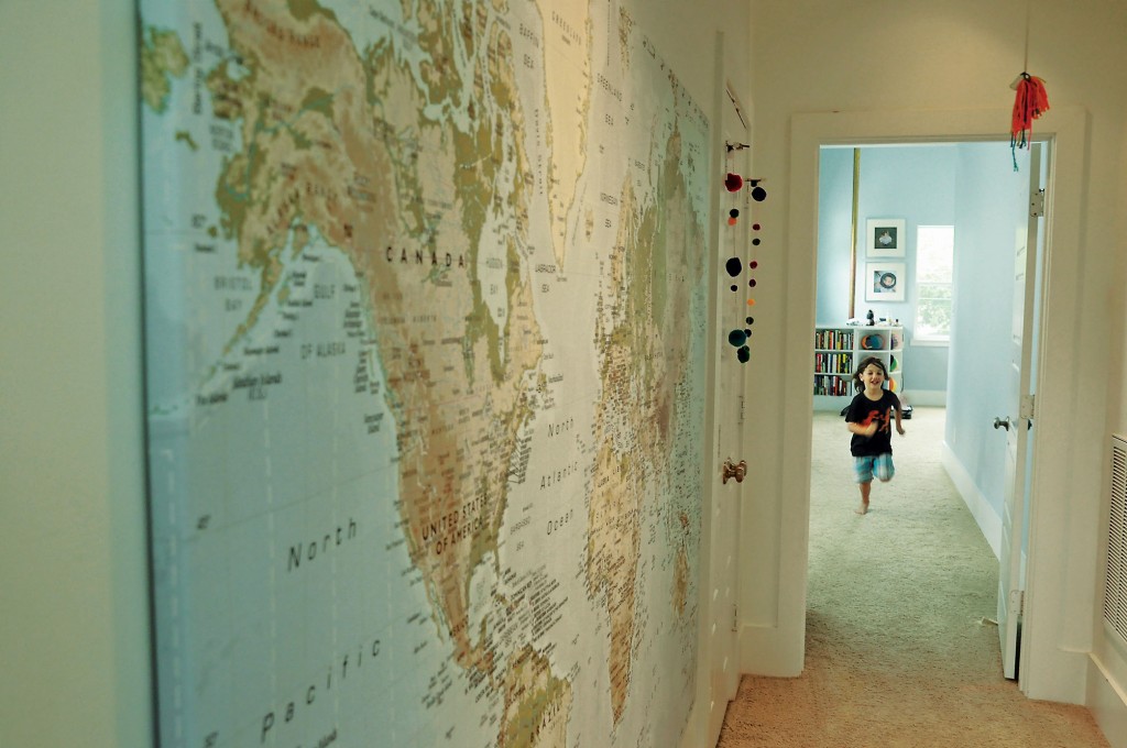 Large wall map from IKEA shows where the family lives and travels. The children made the yarn baubles.