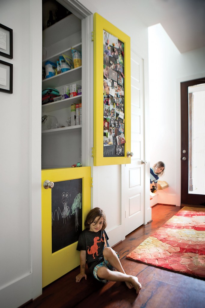 In the entry, mesquite flooring by Canyon Mesquite. Custom-made 8-inch-wide Dutch door in pantry with magnetic chalkboard paint for artwork and photo display. Six-year-old Pace Graff wears a Gnome Enterprises shirt screen-printed in Brooklyn. Three-year-old Brae Graff peers from behind.