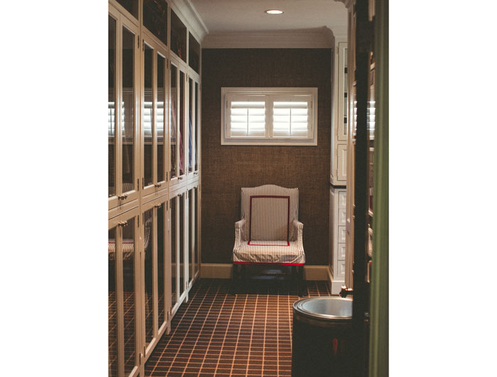 The front wing of Powers' closet– cabinets are glass and walls covered with a rich hue of grasscloth