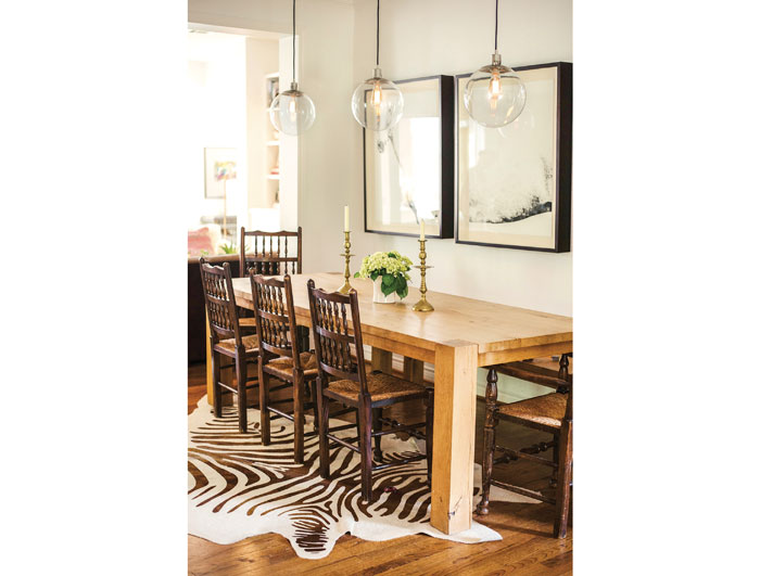 In the dining area, a Crate & Barrel Big Sur table is attended by chairs that belonged to Paula's mother. West Elm pendants. Zebra-print cowhide rug.