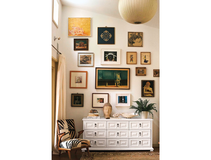 In the master bedroom, Paula had a vintage chest lacquered white. Vintage Buddha head from Brittany Cobb's Dallas Flea. The photos and artwork are mostly flea-market finds, but the photo of a school in Zanzibar (right) was taken by Paula on her honeymoon.