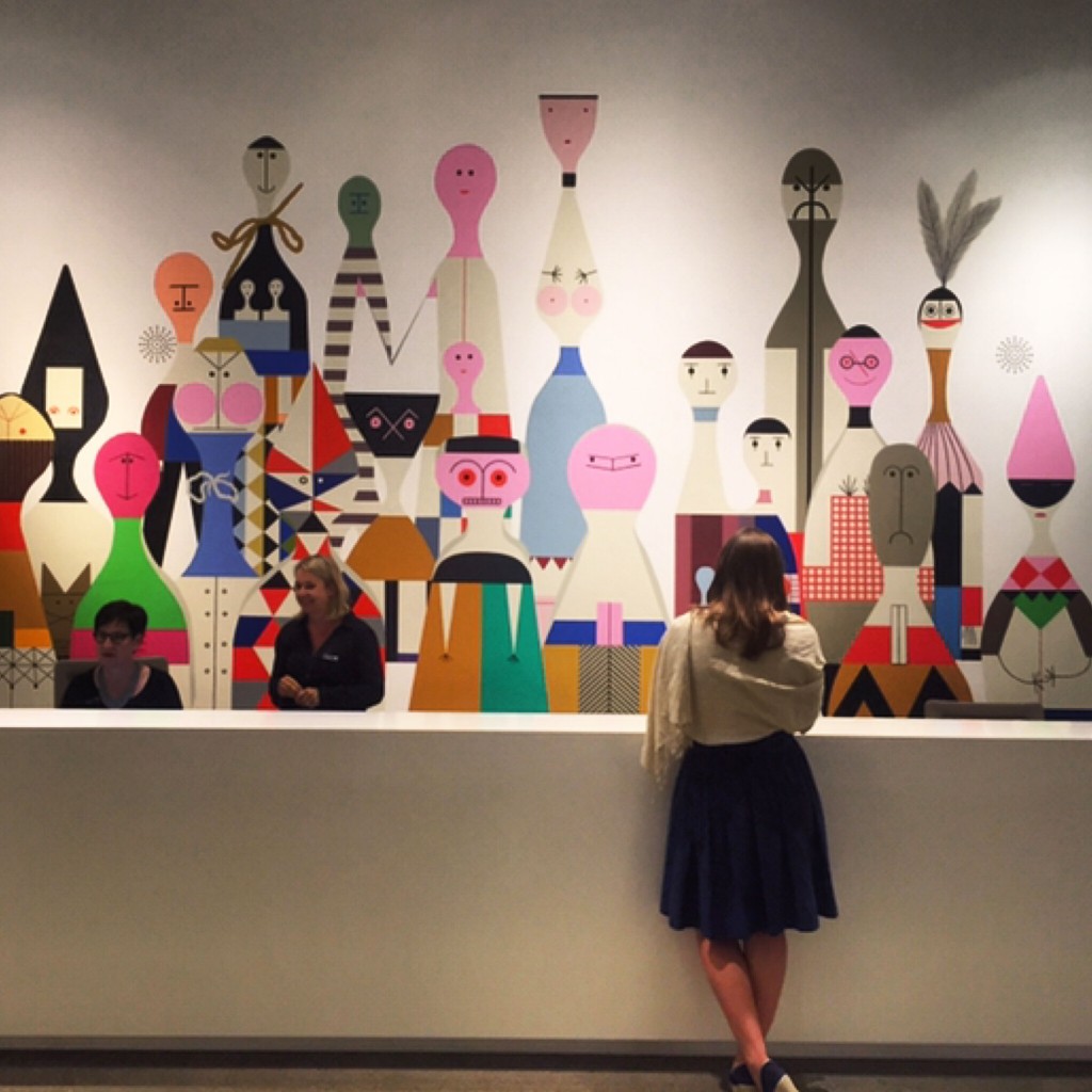 "Wooden Dolls" mural by Alexander Girard makes a fun backdrop reception desk mural at the Vitra Haus Reception | Weil am Rhein, Germany.
