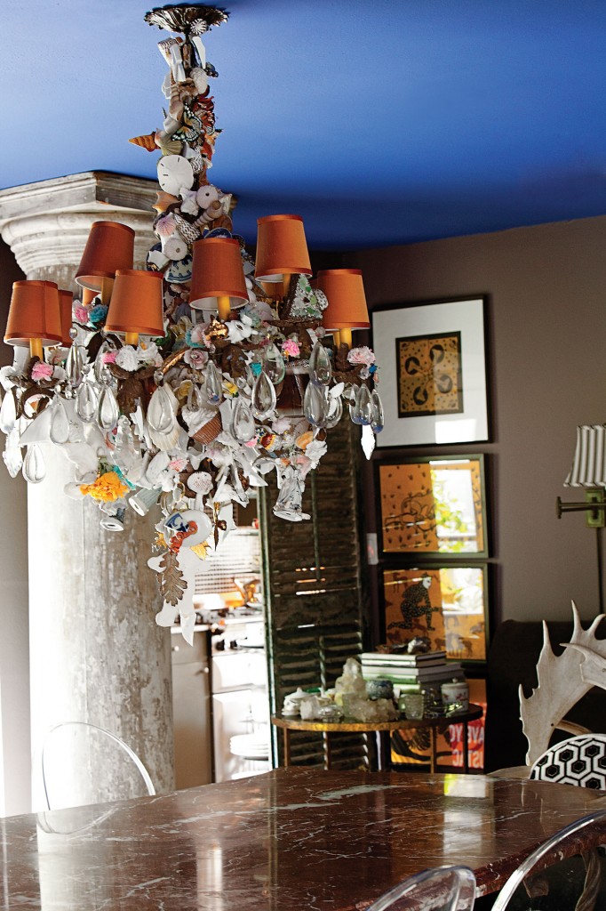 From the Yves Klein-blue bistro ceiling hangs an iron-and-rock crystal chandelier, which was started by Franco Mondini-Ruiz then further adorned and embellished by Cathy. A pair of distressed Ionic columns from Ann Gunnels flanks the windows. The red Venetian marble dining table is from the estate of an antique dealer.