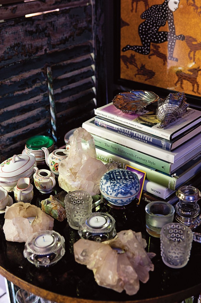 A tight tabletop view in the bistro shows books topped with silver from the Herb Wells estate, rock crystal, Limoges, hand-blown glass votives and a miniature tea set that belonged to Cathy’s mother.
