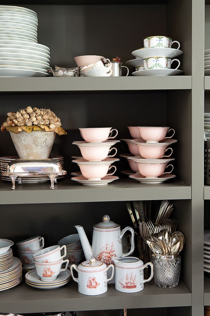 The open shelving of the kitchen houses a collection of Cathy’s china: Limoges, Haviland Marie Antoinette, Spoke Tradewinds and Castletown China Shell Pink grouping, along with vintage silver flatware, silver serving pieces and a dried Mother’s Day floral arrangement from Cathy’s son, Stuart.