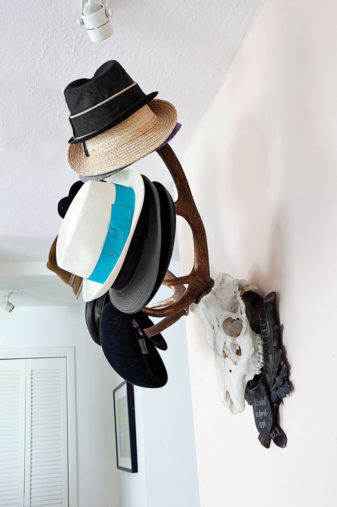 Antique mounted skull with horns in the upper entry, with a collection of hats from Ralph Lauren and Hermès.