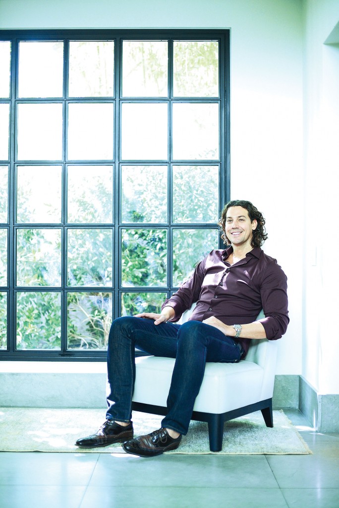 McFarlain relaxes in the vestibule near his kitchen. Christian Liaigre chair. Oushak rug from Abrash.