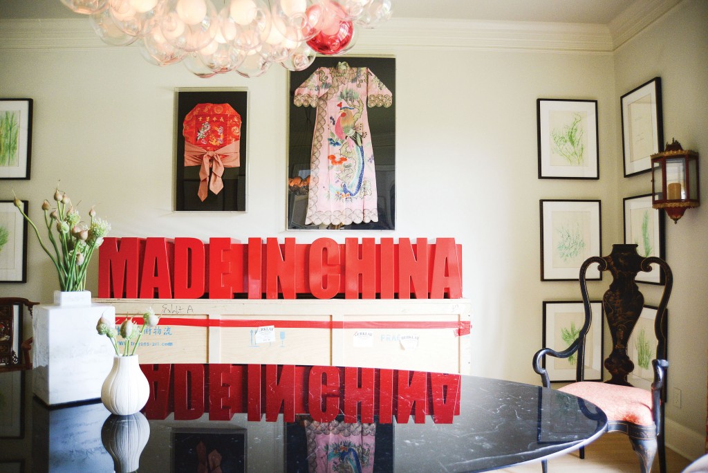 In the dining room, Saarinen oval dining table from Design Within Reach. Antique painted Chinese chair, one of a pair from The Mews. Bocci pendant light from Scott + Cooner. Set of framed rubbings by Italian artist Giuseppe Penone. “Made In China” sign by Chinese artist Sui Jianguo. Framed antique Asian textiles.
